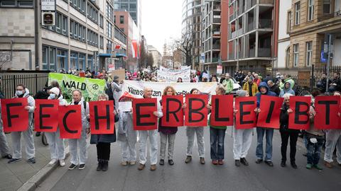 Teilnehmer halten während einer Demonstration Schilder hoch, auf denen "Fecher bleibt" steht.