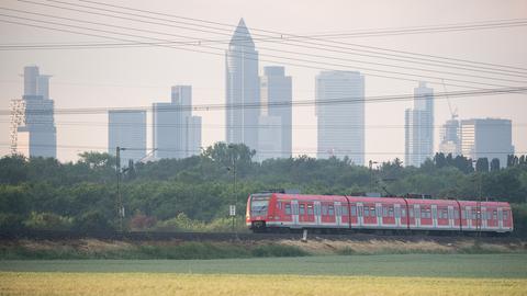 Die S-Bahn zwischen Friedrichsdorf und Frankfurt Südbahnhof (S5) fährt vor der Kulisse der Frankfurter Skyline vorbei.