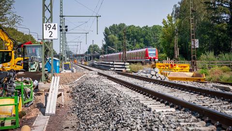 Eine rot-weiße S-Bahn fährt auf Gleisen - aus der Froschperspektive fotografiert. 