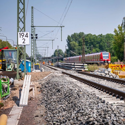 Eine rot-weiße S-Bahn fährt auf Gleisen - aus der Froschperspektive fotografiert. 
