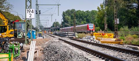 Eine rot-weiße S-Bahn fährt auf Gleisen - aus der Froschperspektive fotografiert. 