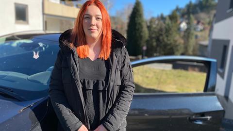 Jessica steht vor ihren Auto