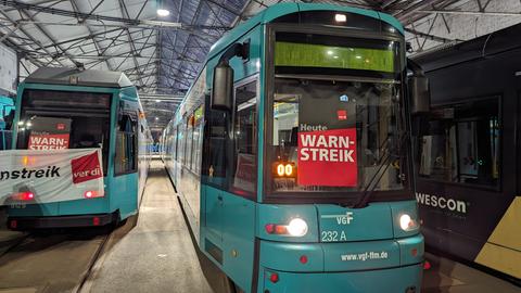 Zwei Straßenbahnen stehen mit Verdi-Streikfahnen dekoriert im Straßenbahndepot in Frankfurt