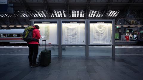 Warten auf den Zug: Eine Reisende am Frankfurter Hauptbahnhof