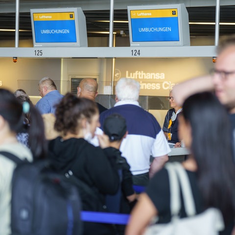 Reisende warten am Frankfurter Flughafen in der Mittagszeit an den Umbuchungs-Schaltern der Lufthansa. Wegen des Verdi-Warnstreiks hat die Lufthansa für Mittwoch (27.07.2022) nahezu ihren kompletten Flugplan abgesagt.