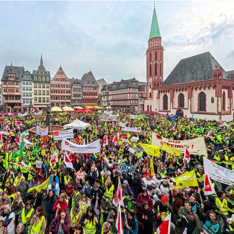 Hunderte Teilnehmende - viele mit gelben Warnwesten - mit Verdi-Fahnen und Transparenten einer Verdi-Kundgebung auf dem Römerberg in Frankfurt
