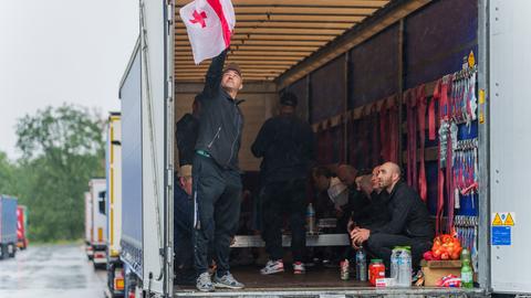 Ein streikender Fahrer hängt eine georgische Nationalflagge an einem Lkw-Auflieger auf.