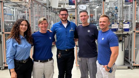 Aylin Kececi (links) und Philipp Langenberg (2.v.r.) stehen mit Melanie Keller, Patrick Zeuch und Rafael Nowak aus der "Aga" im Bereich zwischen neuer Produktion und der alten Abgasanlagenfertigung.