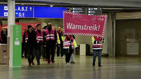 Menschen demonstrieren, Schild "Warnstreik"