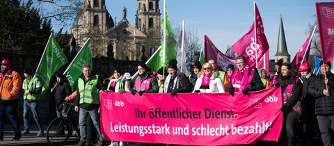 "Ihr öffentlicher Dienst: Leistungsstark und schlecht bezahlt" steht während eines Warnstreiks auf einem Banner am Demonstrationszug. 