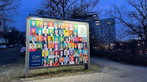 Vor dem Gebäude von Wintershall Dea in Kassel steht ein Plakat mit Bildern von Mitarbeitenden und dem Motto "We embrace diversity"