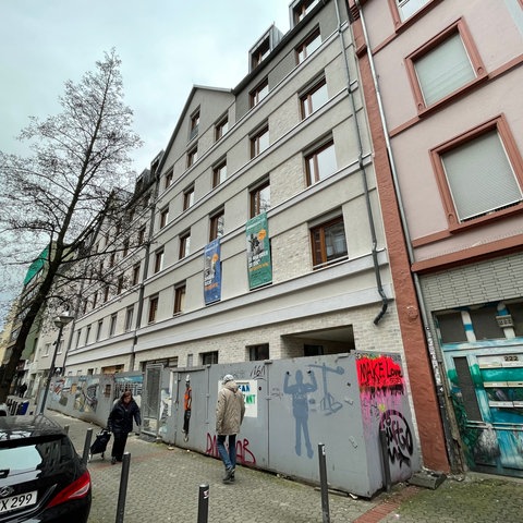 Neues Wohnhaus mit Kita an der Berger Straße in Frankfurt, cremefarbene Fassade, Bauzaun davor