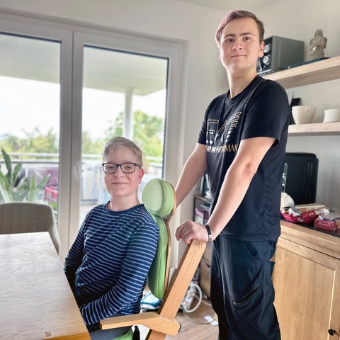 Young Carer Jakob schiebt der Rollstuhl seines Bruders Daniel